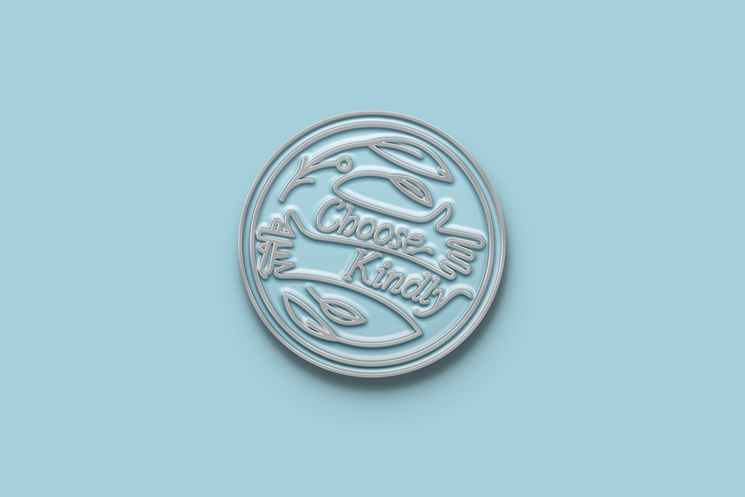 silver round coin on pink surface