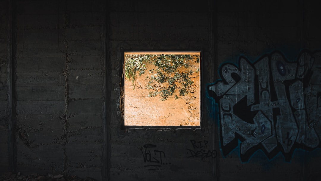 a window in a wall with graffiti on it