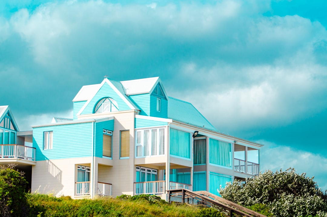 A blue and white house sitting on top of a hill