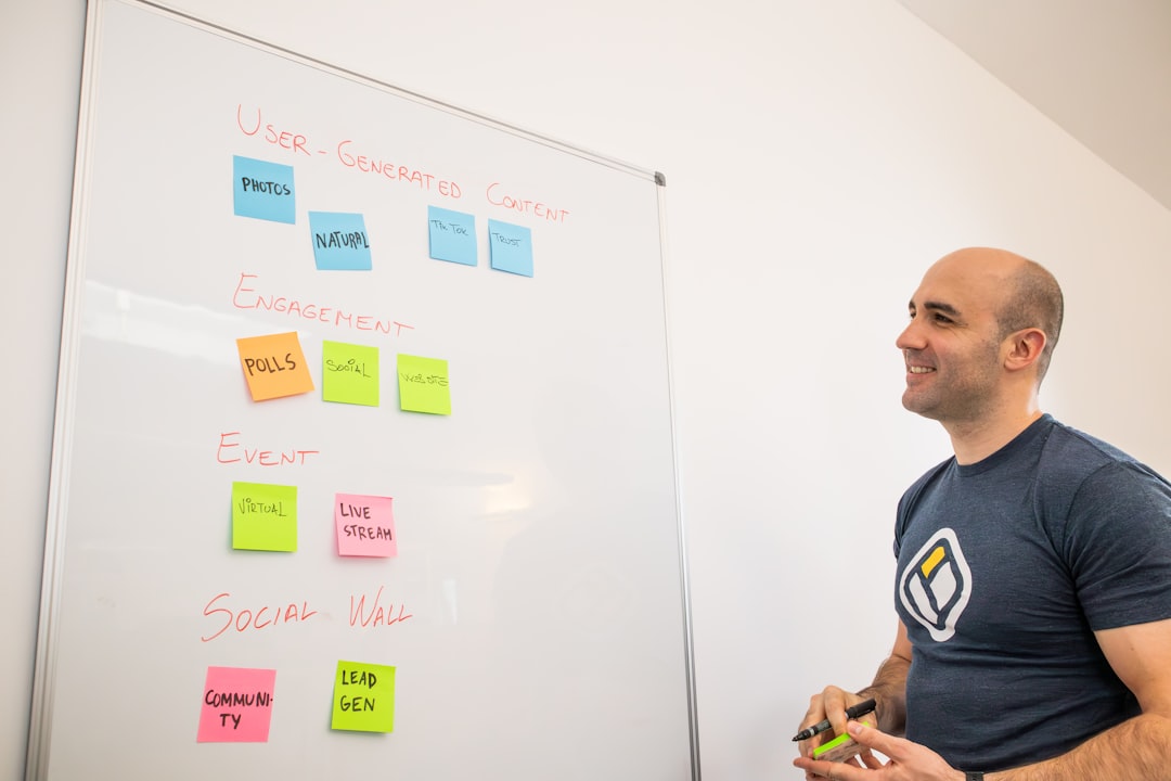 a man standing in front of a white board with sticky notes on it